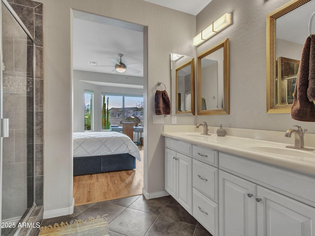 bathroom with tile patterned flooring, vanity, a shower with shower door, and ceiling fan