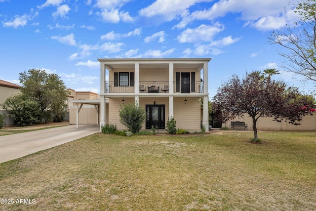 view of front of house with fence, an attached carport, a balcony, a front lawn, and concrete driveway