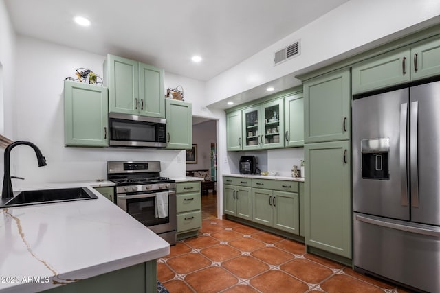 kitchen with recessed lighting, stainless steel appliances, green cabinets, a sink, and visible vents