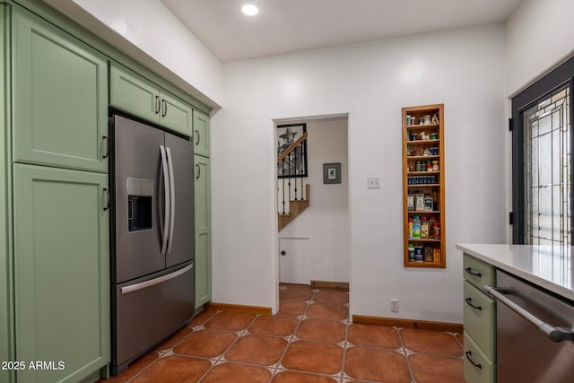 kitchen with recessed lighting, stainless steel fridge, light countertops, green cabinets, and baseboards
