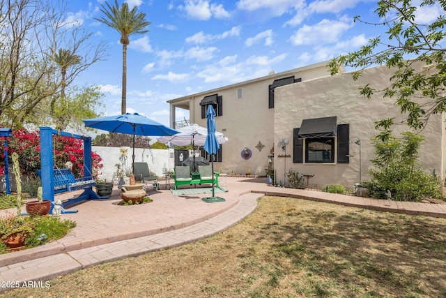 rear view of property featuring stucco siding and a patio area