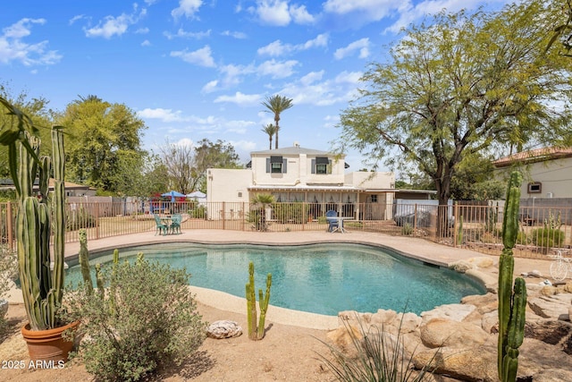 view of swimming pool featuring a patio, fence, and a fenced in pool