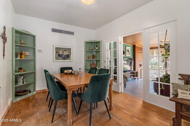 dining space with visible vents and wood finished floors
