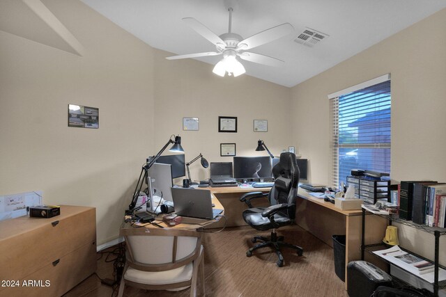 home office featuring hardwood / wood-style floors, vaulted ceiling, and ceiling fan