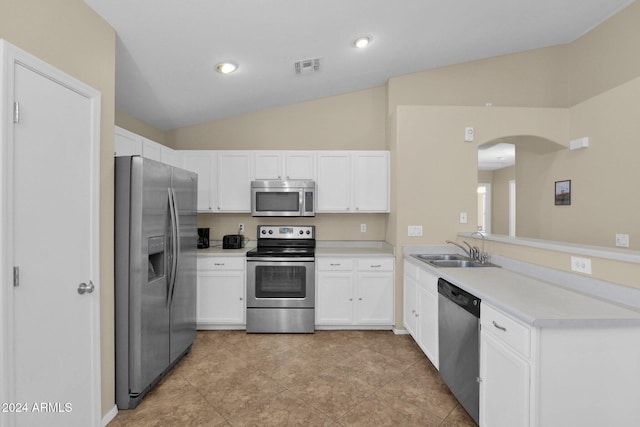 kitchen with white cabinets, stainless steel appliances, lofted ceiling, and sink