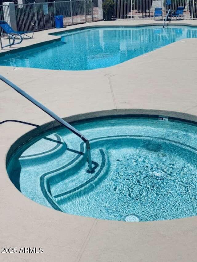 pool featuring fence and a patio area