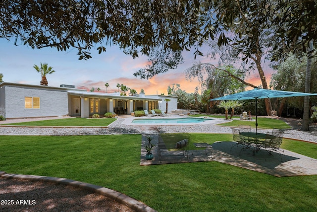 6911 E Thunderbird Rd, Scottsdale, AZ 85254 - pool at dusk with a patio area, a lawn, and an outdoor pool
