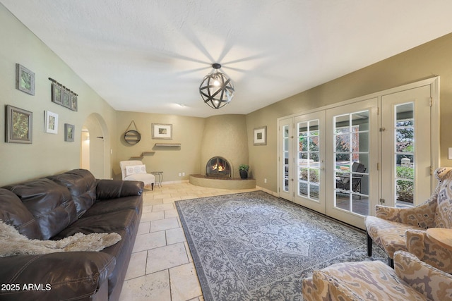 6911 E Thunderbird Rd, Scottsdale, AZ 85254 - living room featuring arched walkways, french doors, and stone tile floors