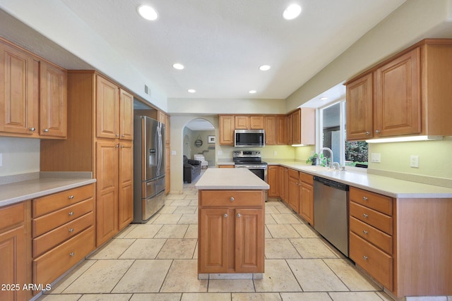 6911 E Thunderbird Rd, Scottsdale, AZ 85254 - kitchen featuring appliances with stainless steel finishes, arched walkways, a kitchen island, recessed lighting, and light countertops