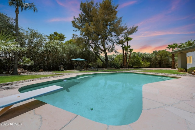 6911 E Thunderbird Rd, Scottsdale, AZ 85254 - pool at dusk featuring an outdoor pool, a diving board, and a patio