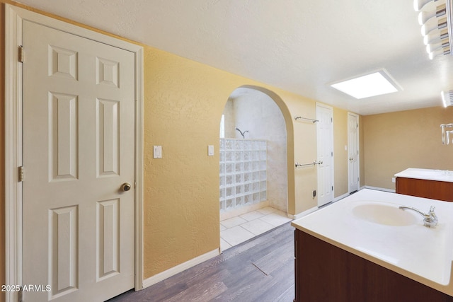 6911 E Thunderbird Rd, Scottsdale, AZ 85254 - full bath with a textured wall, a walk in shower, vanity, wood finished floors, and a textured ceiling