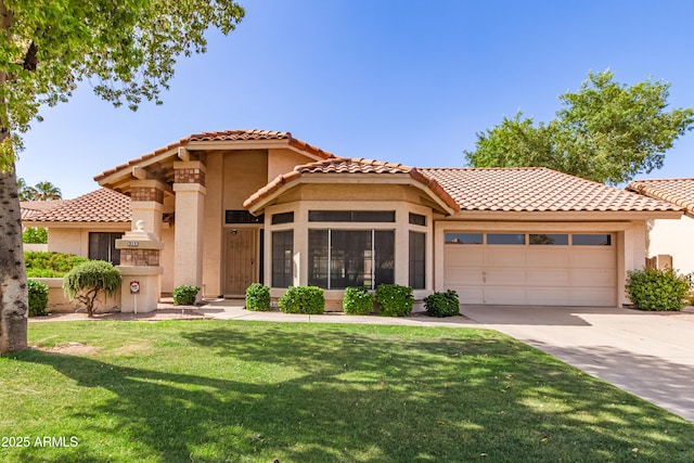 1258 E Granada St, Mesa, AZ 85203 - mediterranean / spanish house featuring a garage, driveway, a tiled roof, stucco siding, and a front lawn