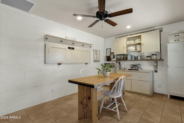 kitchen featuring a kitchen breakfast bar, ceiling fan, butcher block countertops, and cream cabinetry