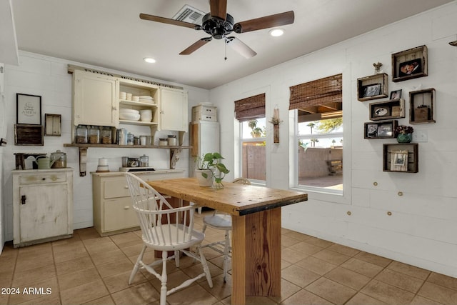 kitchen featuring wooden counters, light tile patterned floors, a breakfast bar, and ceiling fan