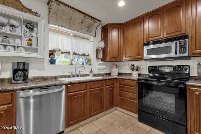 kitchen with tasteful backsplash, sink, light tile patterned flooring, and stainless steel appliances