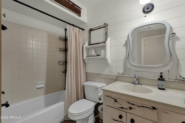 full bathroom featuring wooden walls, shower / bath combo with shower curtain, vanity, and toilet