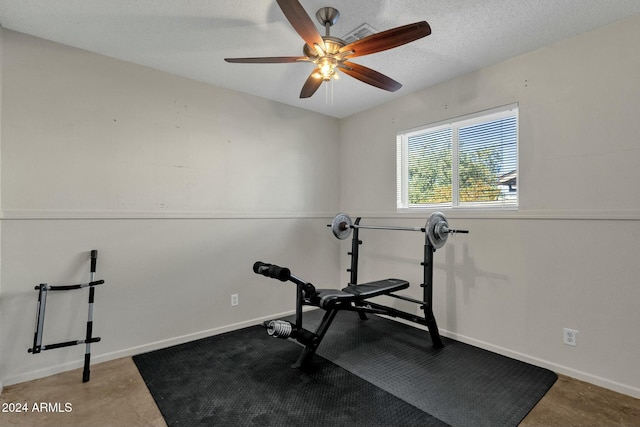 exercise area with ceiling fan and a textured ceiling