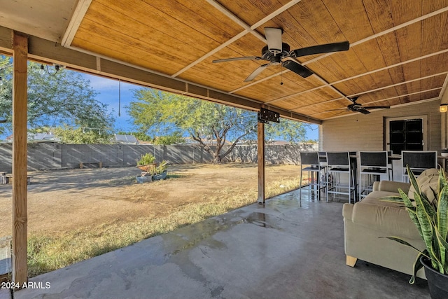 view of patio / terrace with ceiling fan and a bar