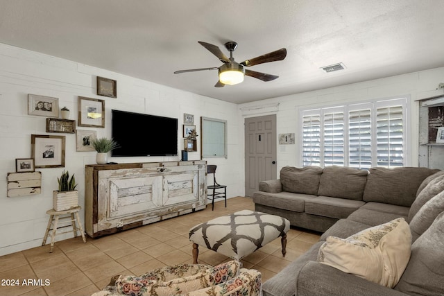 tiled living room featuring ceiling fan and a textured ceiling