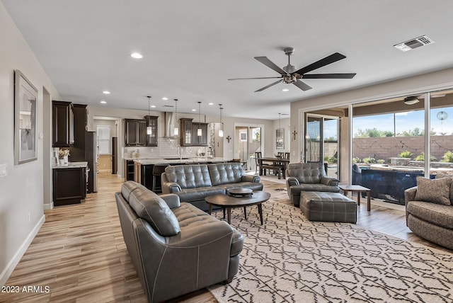 14655 W Pasadena Ave, Litchfield Park, AZ 85340 - living area featuring light wood-style floors, ceiling fan, baseboards, and visible vents