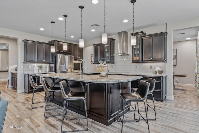 14655 W Pasadena Ave, Litchfield Park, AZ 85340 - kitchen featuring stainless steel appliances, visible vents, wall chimney exhaust hood, and a center island with sink