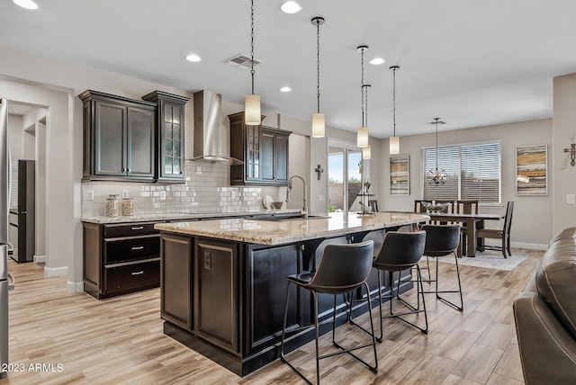 14655 W Pasadena Ave, Litchfield Park, AZ 85340 - kitchen featuring tasteful backsplash, a sink, wall chimney range hood, and baseboards