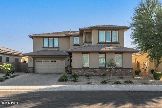 14655 W Pasadena Ave, Litchfield Park, AZ 85340 - prairie-style house featuring stucco siding, stone siding, decorative driveway, an attached garage, and fence