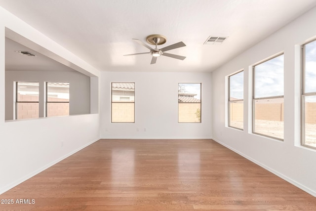 304 E Beth Dr, Phoenix, AZ 85042 - unfurnished room with healthy amount of natural light, wood finished floors, and ceiling fan