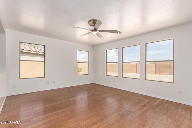 304 E Beth Dr, Phoenix, AZ 85042 - unfurnished room featuring healthy amount of natural light, wood finished floors, a ceiling fan, and baseboards