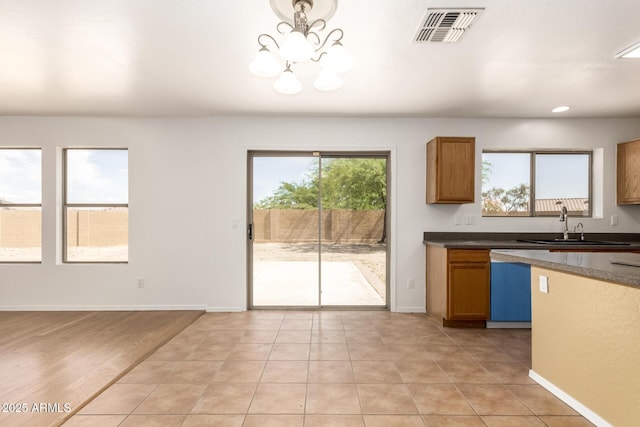 304 E Beth Dr, Phoenix, AZ 85042 - kitchen featuring dishwashing machine, dark countertops, brown cabinetry, a sink, and recessed lighting