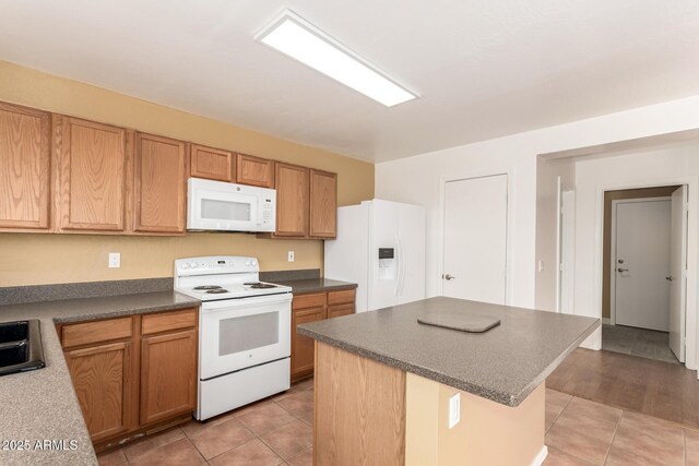 304 E Beth Dr, Phoenix, AZ 85042 - kitchen featuring white appliances, light tile patterned flooring, a center island, dark countertops, and a sink