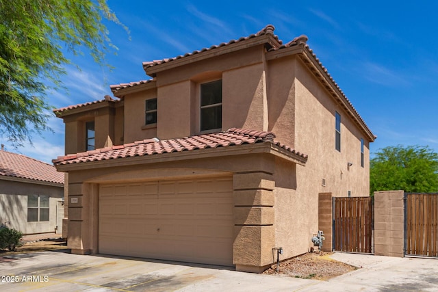 304 E Beth Dr, Phoenix, AZ 85042 - mediterranean / spanish house featuring an attached garage, driveway, stucco siding, and a tile roof