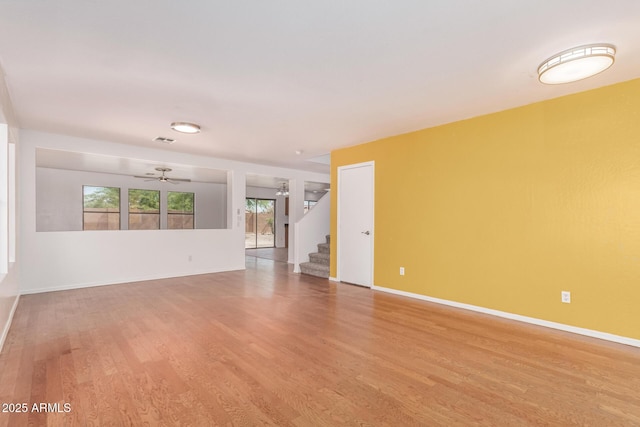 304 E Beth Dr, Phoenix, AZ 85042 - unfurnished living room featuring light wood-type flooring, stairs, ceiling fan, and baseboards