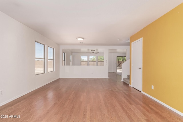 304 E Beth Dr, Phoenix, AZ 85042 - unfurnished living room featuring wood finished floors, stairs, a ceiling fan, and baseboards