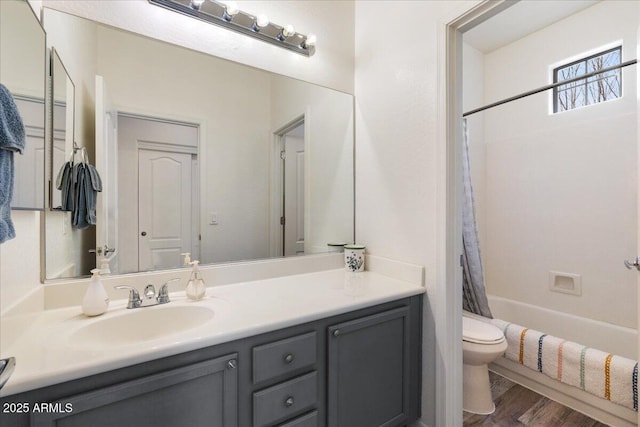 bathroom featuring shower / bathtub combination with curtain, toilet, vanity, and wood finished floors