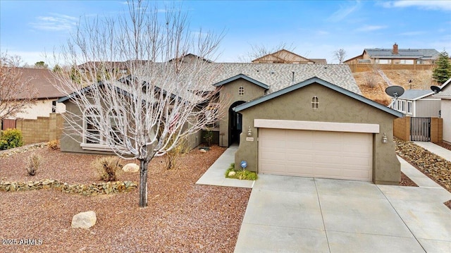 ranch-style house featuring fence, a garage, driveway, and stucco siding