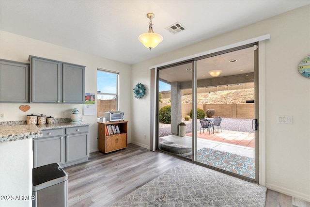 entryway with baseboards, visible vents, and light wood-type flooring