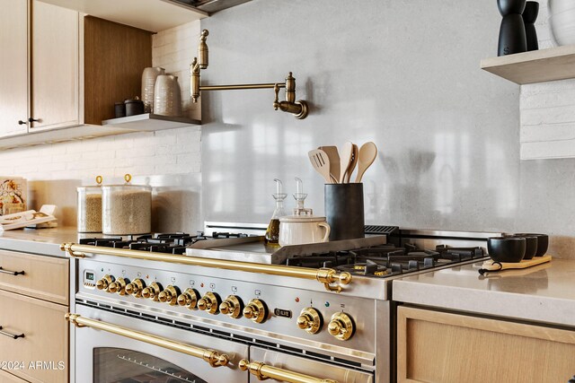 kitchen featuring tasteful backsplash, double oven range, and light brown cabinets