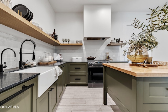 kitchen featuring light tile patterned flooring, wall chimney range hood, decorative backsplash, range with electric cooktop, and wood counters