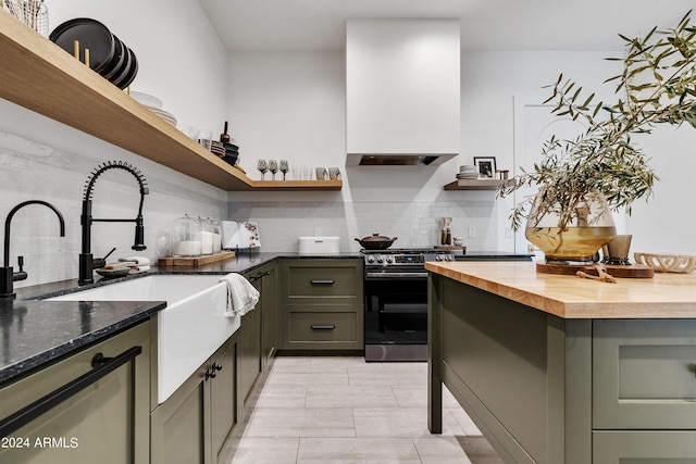 kitchen featuring open shelves, premium range hood, stainless steel range, and a sink