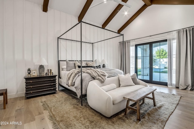 bedroom featuring high vaulted ceiling, light wood-type flooring, and beam ceiling