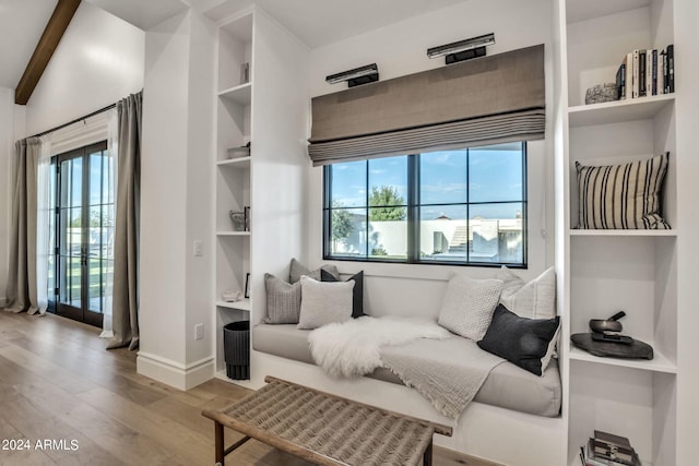 living room with built in shelves and light hardwood / wood-style flooring