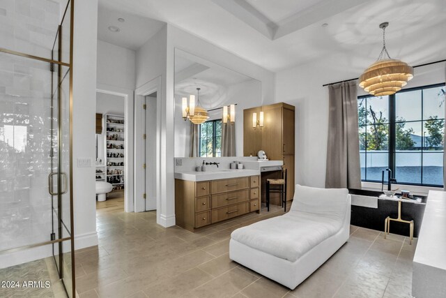 bathroom featuring an inviting chandelier, vanity, tile patterned floors, and walk in shower