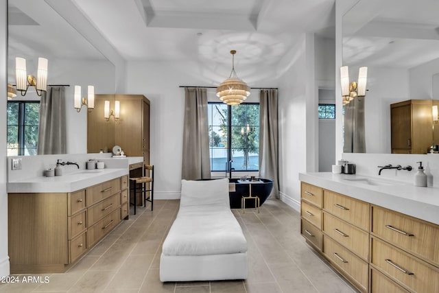 full bath with baseboards, two vanities, a sink, and a freestanding bath