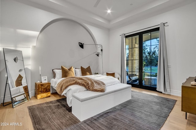 bedroom featuring access to exterior, arched walkways, recessed lighting, wood finished floors, and baseboards