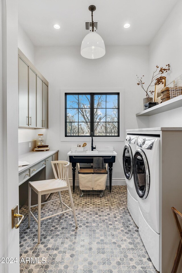 washroom featuring light tile patterned flooring, washing machine and clothes dryer, and cabinets