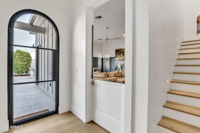 doorway with light hardwood / wood-style floors and ceiling fan