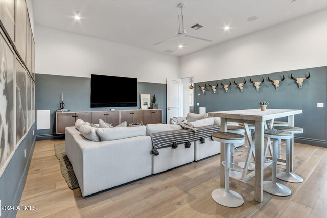 living room with light hardwood / wood-style floors and ceiling fan