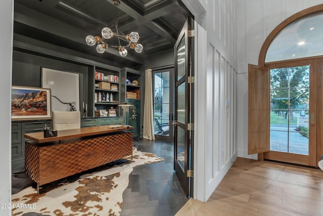 interior space with beam ceiling, coffered ceiling, and a chandelier