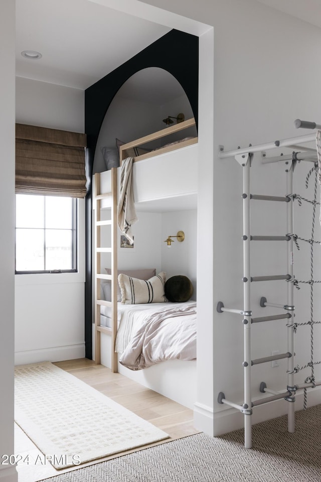 bedroom featuring light carpet and baseboards